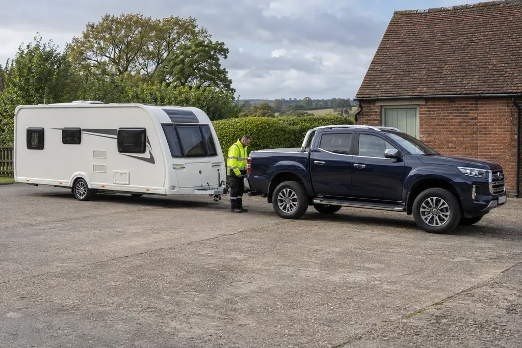 Touring caravan coupled to a recovery tow vehicle on a level yard